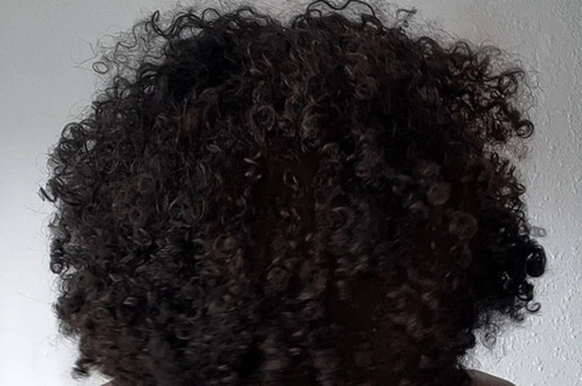 Close-up of tightly coiled natural hair showing coarse texture